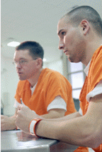 Picture of two inmates listening to someone out of the frame.