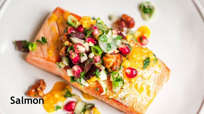 Photo of a plate of salmon with pomegranates and walnuts.