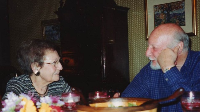 Photo of two older people sitting at a table.