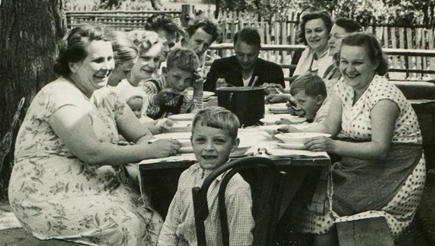 Photo of a large family sitting around a picnic table.