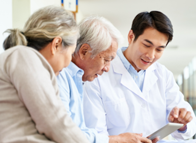 Elderly couple and male doctor looking at tablet together