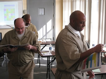 Photograph of a men-only class held in an Indiana state prison.  The photograph shows a small number of incarcerated men reading workbooks.