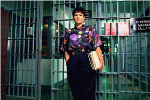 Picture of a female corrections officer in front of a cell.
